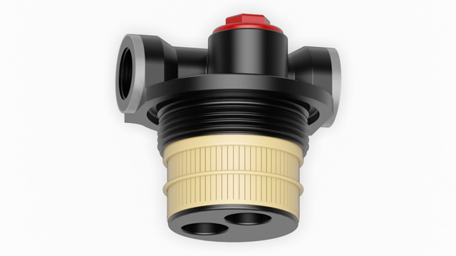 Schwarze Anschlussarmatur mit einem roten Knopf und zwei Anschlüssen für Rohrleitungen.