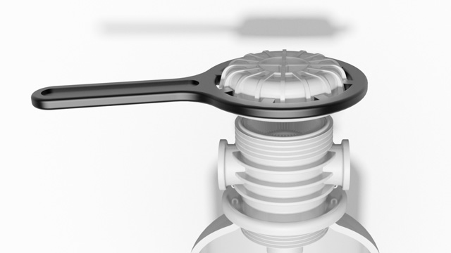 Schwarze Abdeckung für eine Anschlussarmatur, die auf einem weißen Verbindungselement platziert ist.