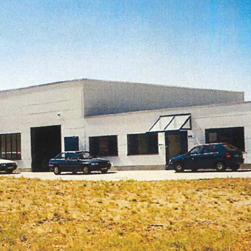 Das KSH GmbH Gebäude aus den 1990er Jahren mit mehreren Autos auf dem Parkplatz.