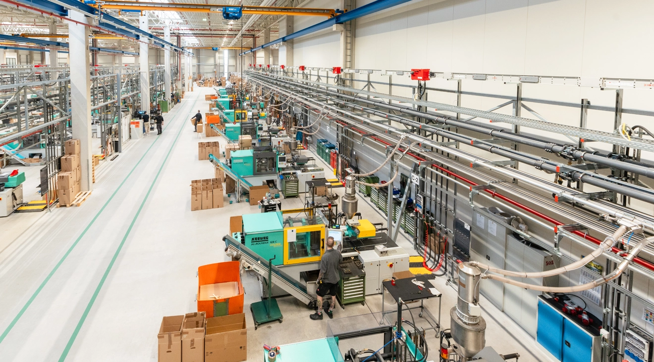 Blick auf eine Produktionshalle mit mehreren Maschinen und Arbeitsplätzen für die Fertigung.